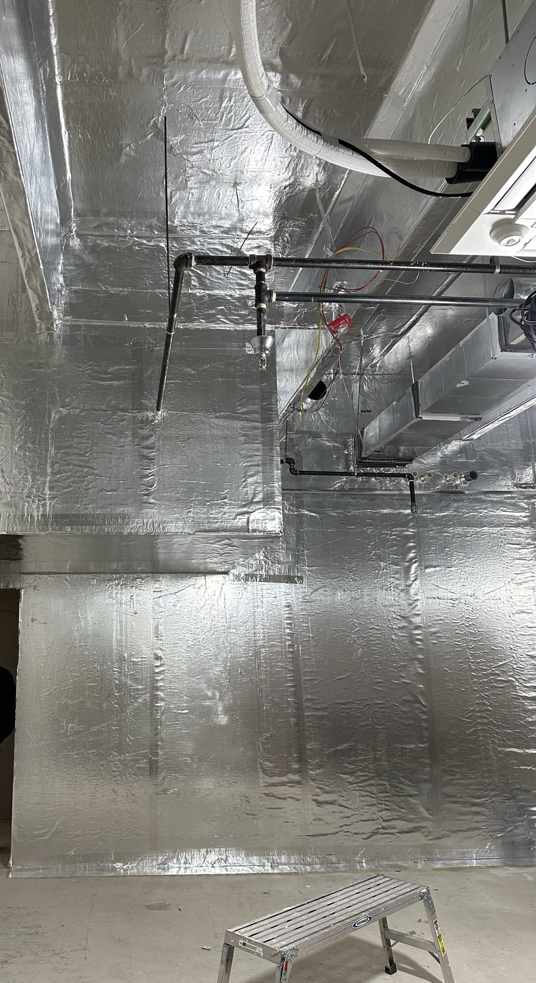 Reflective shielding installed across walls and overhead systems